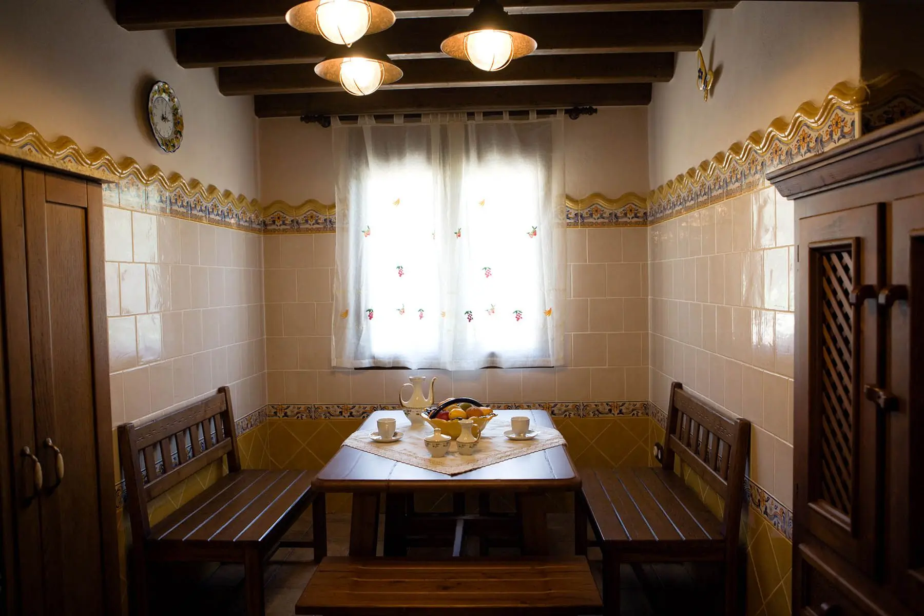 Rincón de comedor de la cocina, con mesa y bancos de madera