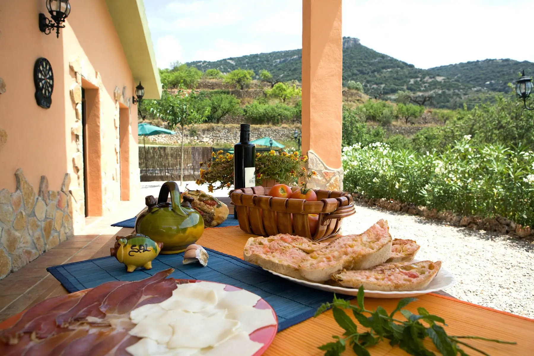 Mesa con desayuno en la terraza de Mas d’Albalat y montañas al fondo
